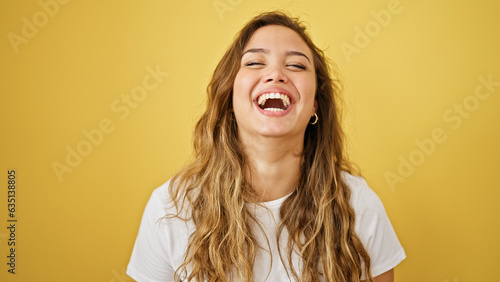 Slika na platnu Young beautiful hispanic woman laughing a lot standing over isolated yellow back