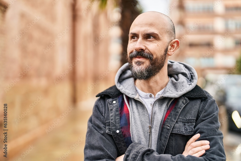Young bald man standing with arms crossed gesture at street Young bald man standing with arms crossed gesture at street