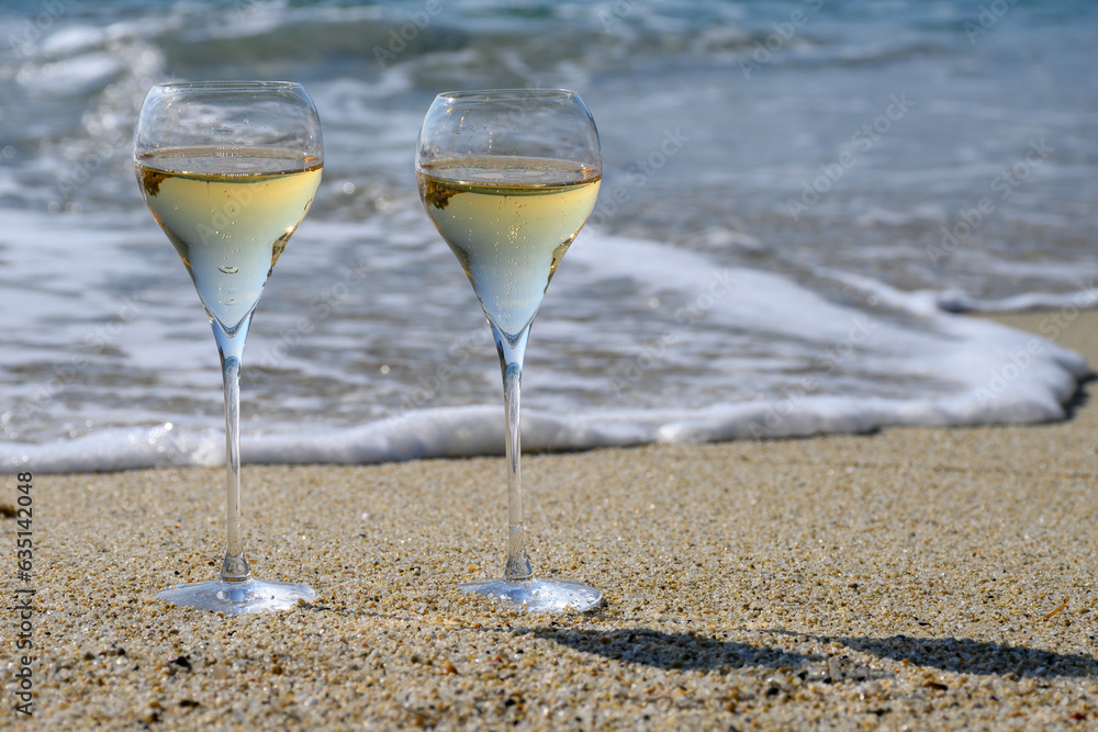 Summer time in Provence, two glasses of cold champagne cremant sparkling wine on sandy beach near Saint-Tropez in sunny day, Var department, France Summer time in Provence, two glasses of cold champagne cremant sparkling wine on sandy beach near Saint-Tropez in sunny day, Var department, France