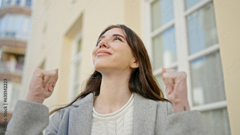 Fototapeta premium Young hispanic woman standing with winner expression at street
