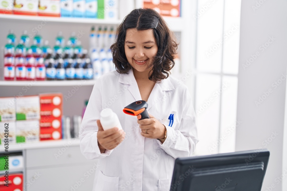 Young woman pharmacist scanning pills bottle at pharmacy