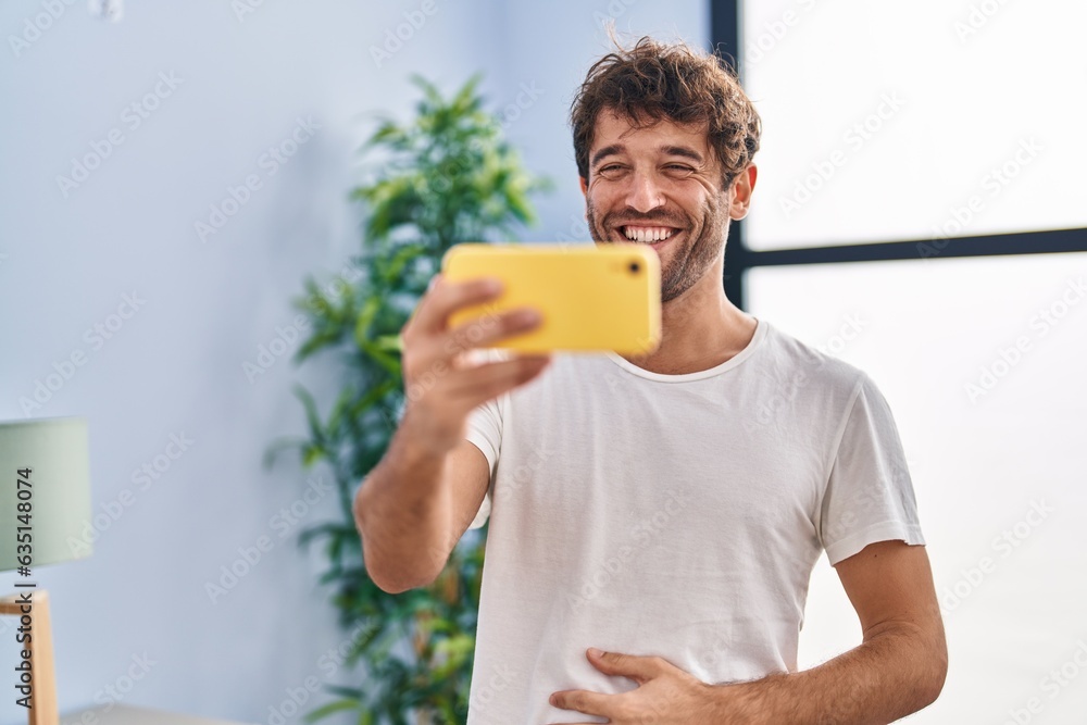 Young man smiling confident watching video on smartphone at home