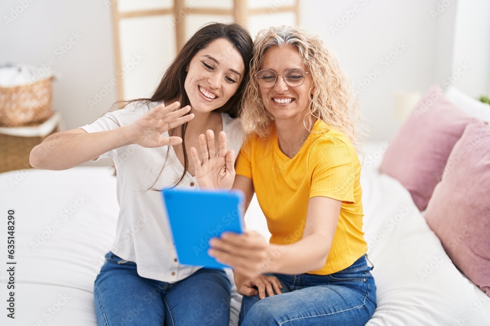 Two women mother and daughter having video call sitting on bed at bedroom Two women mother and daughter having video call sitting on bed at bedroom