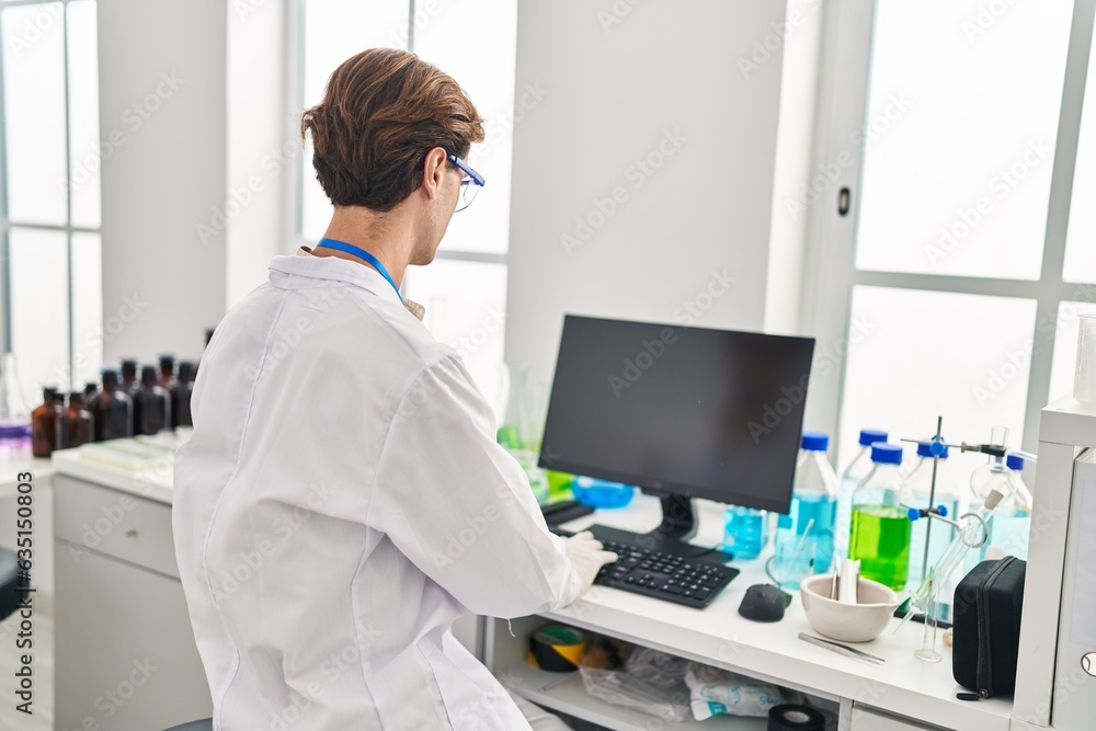 Young caucasian man scientist using computer at laboratory Young caucasian man scientist using computer at laboratory