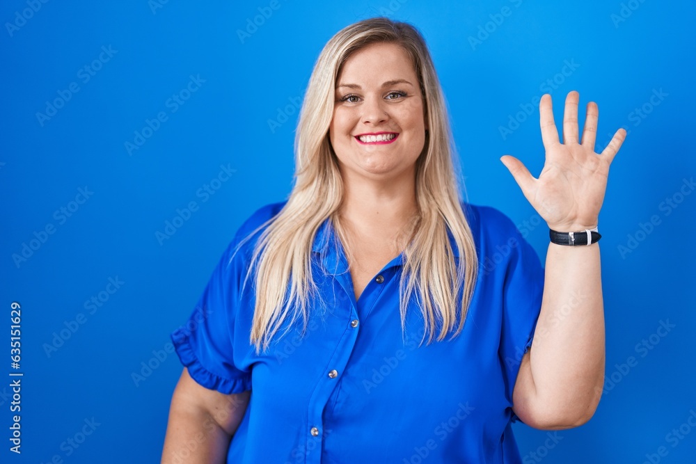 Caucasian plus size woman standing over blue background showing and pointing up with fingers number five while smiling confident and happy. Caucasian plus size woman standing over blue background showing and pointing up with fingers number five while smiling confident and happy.