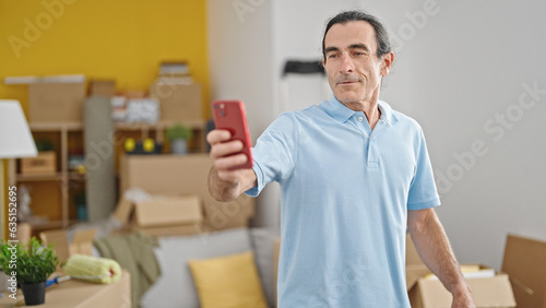 Middle age man having video call smiling at new home