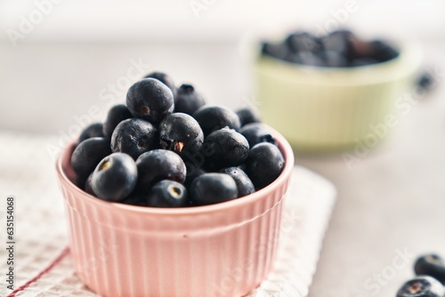  Delicious group of blueberries on ceramic bowls marble surface