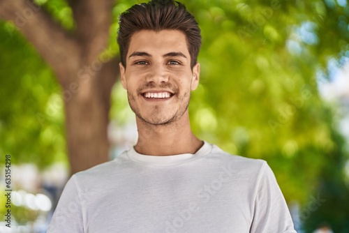 Young hispanic man smiling confident standing at park