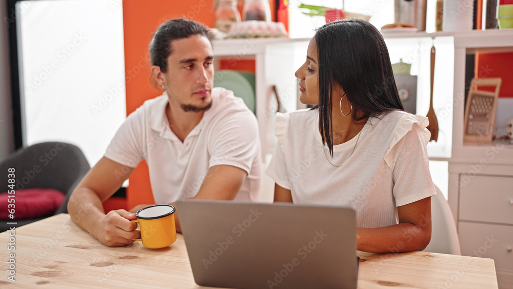 Man and woman couple using laptop drinking coffee at dinning room Man and woman couple using laptop drinking coffee at dinning room