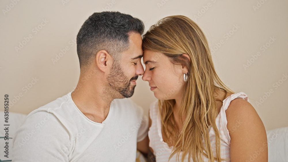 Man and woman couple sitting on bed with heads together at bedroom Man and woman couple sitting on bed with heads together at bedroom