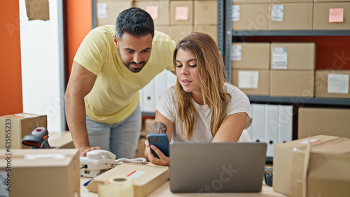 Man and woman ecommerce business workers using smartphone at office