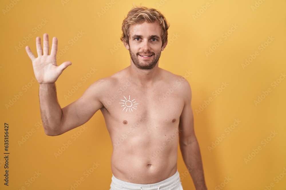 Caucasian man standing shirtless wearing sun screen showing and pointing up with fingers number five while smiling confident and happy.
