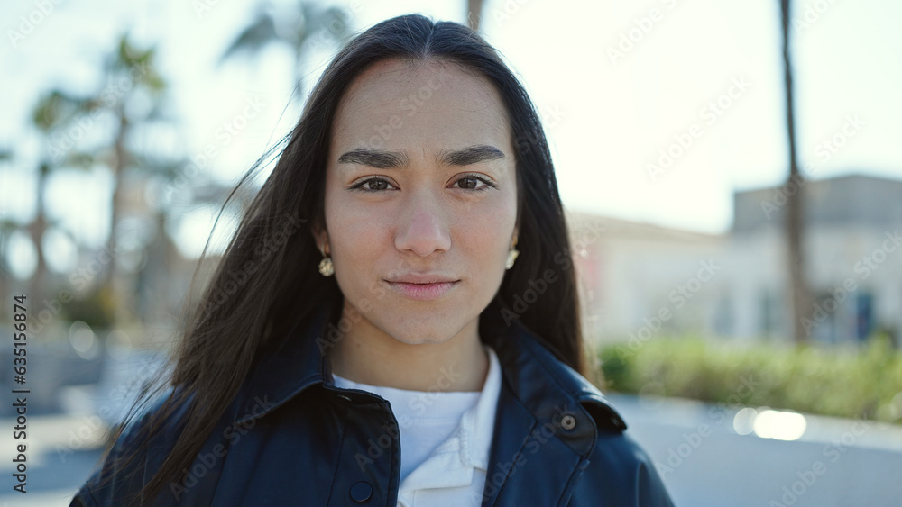 Young beautiful hispanic woman standing with serious expression at street Young beautiful hispanic woman standing with serious expression at street
