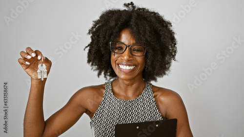 African american woman real state agent holding keys of new home smiling over isolated white background