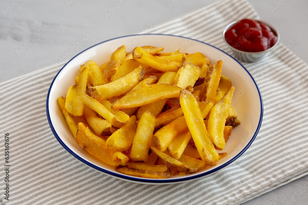 Homemade French Fries with Ketchup on a Plate, side view. Close-up. Homemade French Fries with Ketchup on a Plate, side view. Close-up.