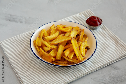 Homemade French Fries with Ketchup on a Plate, side view. Close-up.