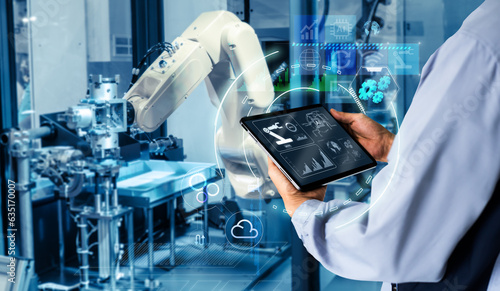 Smart industry control concept.Hands holding tablet on blurred automation machine as background photo