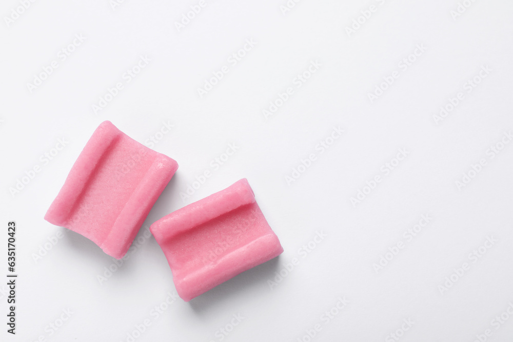 Tasty pink chewing gums on white background, flat lay. Space for text Tasty pink chewing gums on white background, flat lay. Space for text
