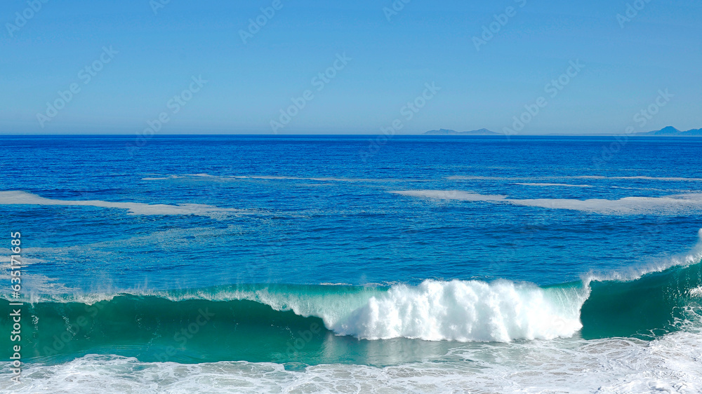 Fototapeta premium powerful cross ocean wave breaking during the day on the beach