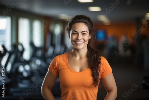 Sporty beautiful woman fitness trainer smiling in the gym