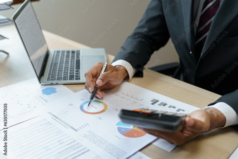 Businessman Accountant analyzing investment charts Invoice and pressing calculator buttons over documents. Accounting Bookkeeper Clerk Bank Advisor And Auditor Concept. Businessman Accountant analyzing investment charts Invoice and pressing calculator buttons over documents. Accounting Bookkeeper Clerk Bank Advisor And Auditor Concept.
