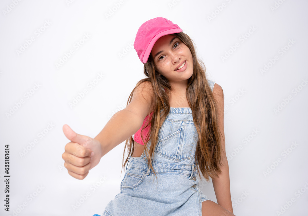 Little girl wearing a pink cap showing thumb up on a white background. Little girl wearing a pink cap showing thumb up on a white background.