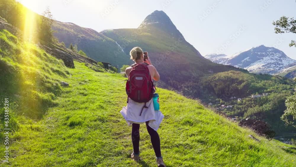 Person taking cellphone photos of majestic mountain landscape on a sunny summer day Person taking cellphone photos of majestic mountain landscape on a sunny summer day