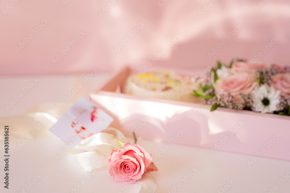 Cake with blooming roses in a pink gift box.