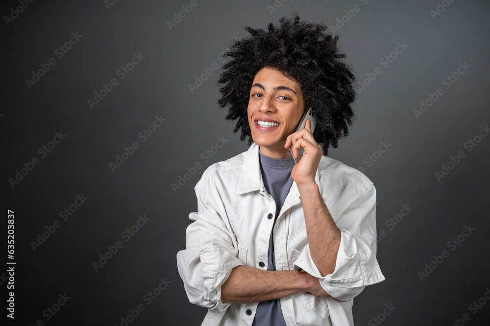 Young dark-haired man talking on the phone and looking excited