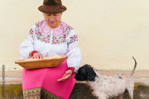 indigenous woman holding corn with her dog photo