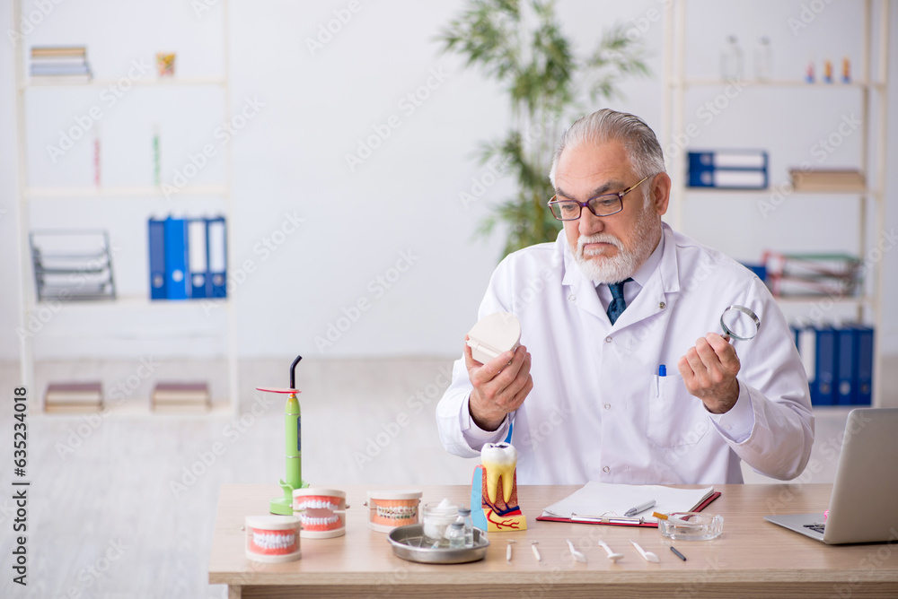 Old male doctor dentist working in the clinic Old male doctor dentist working in the clinic