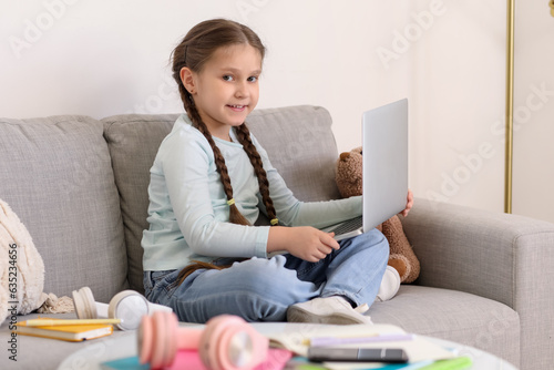 Little girl with laptop stu...
