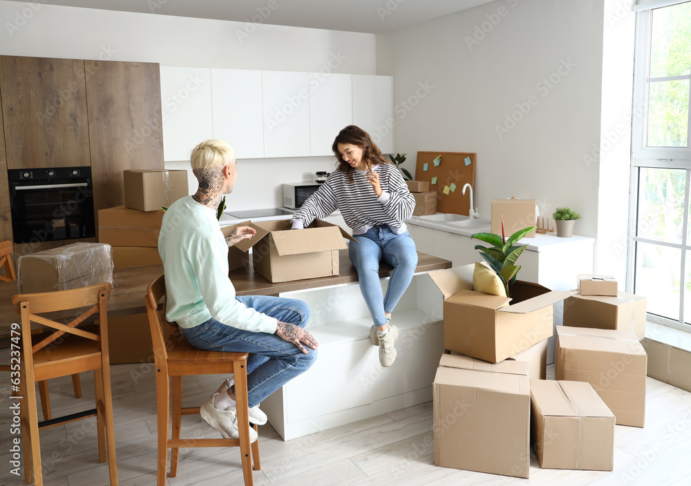 Young couple unpacking things in kitchen on moving day Young couple unpacking things in kitchen on moving day