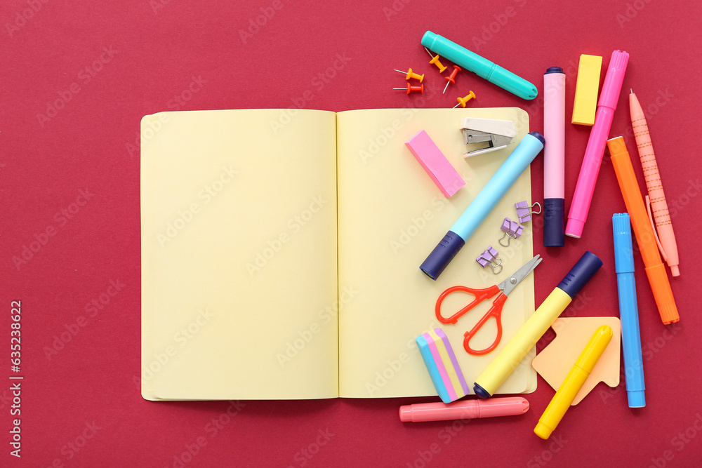 Composition with blank open notebook and school supplies on color background Composition with blank open notebook and school supplies on color background