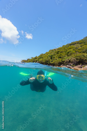 split shot of a girl doing snorkel with stinger suit