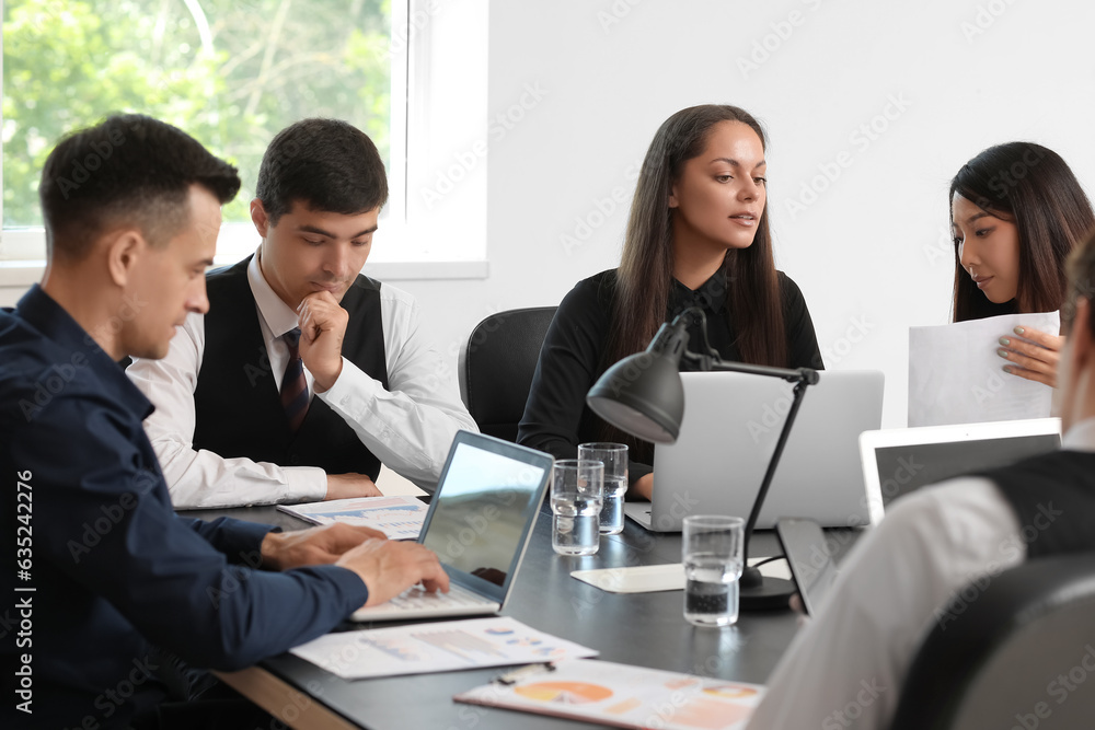 Group of business consultants working at table in office Group of business consultants working at table in office