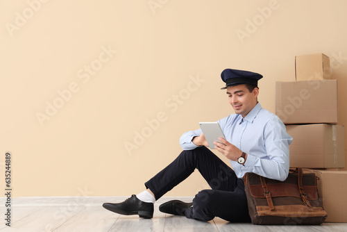Young postman with tablet c...