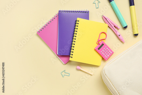 Pencil case with different school stationery on beige background, closeup