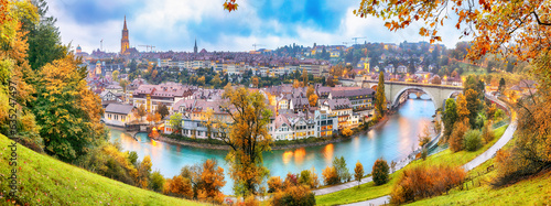 Fabulous autumn view of Bern city on Aare river during evening with Pont de Nydegg bridge , cathedral of Bern and Nydeggkirche - Protestant church.