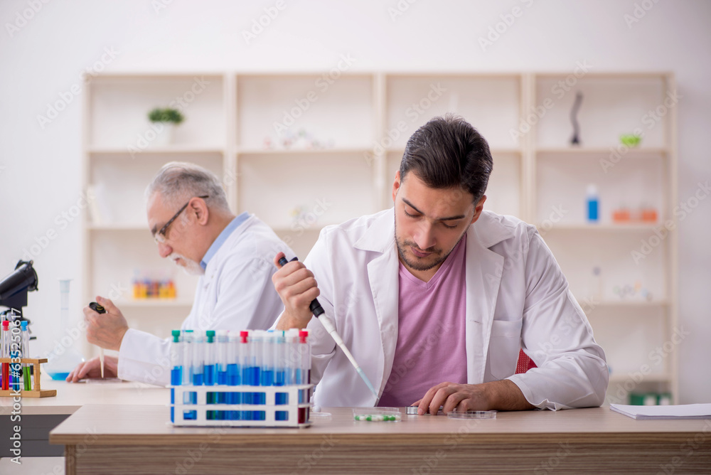 Two male chemists working at the lab Two male chemists working at the lab
