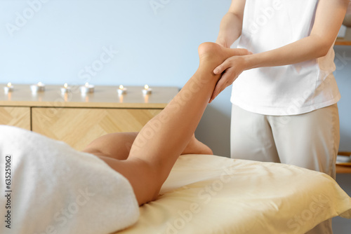 Beautiful woman receiving leg massage in spa salon