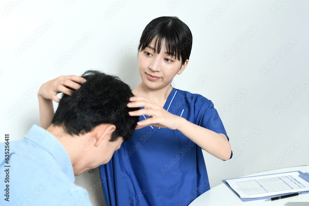 Fototapeta premium 薄毛治療の診断をする医師と男性患者 