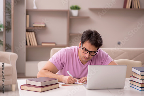 Young male student preparing for exams at home photo