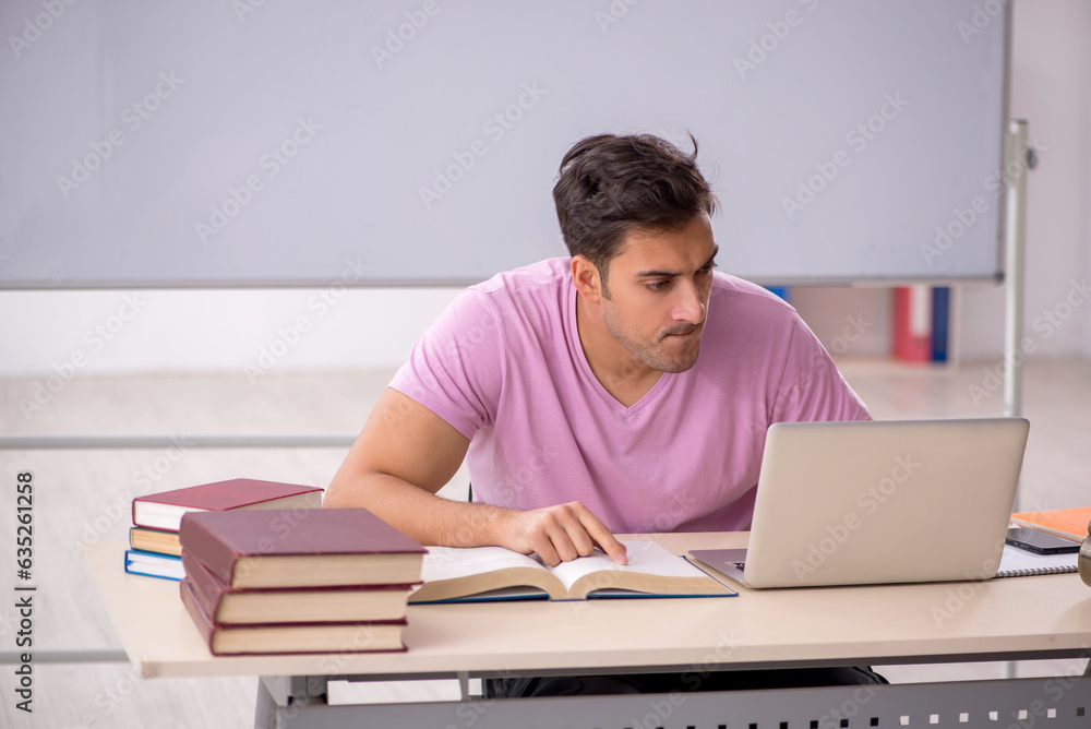 Young male student preparing for exams in the classroom Young male student preparing for exams in the classroom