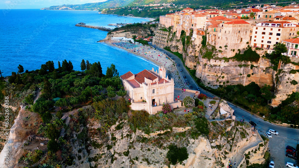 Aerial view of picturesque famous  village Tropea, Italy with it's historic houses on cliff and azure sea water 