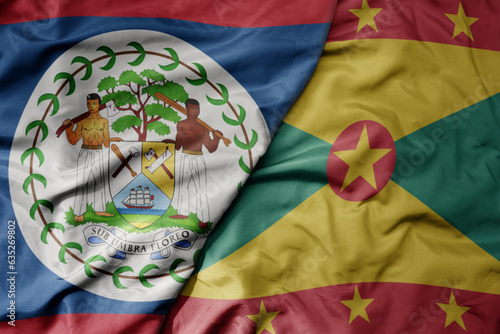 big waving realistic national colorful flag of belize and national flag of grenada .
