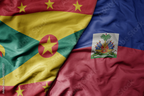 big waving realistic national colorful flag of grenada and national flag of haiti .