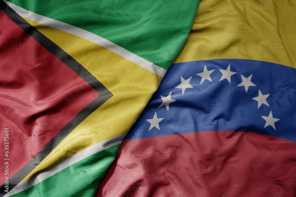 big waving realistic national colorful flag of guyana and national flag of venezuela .