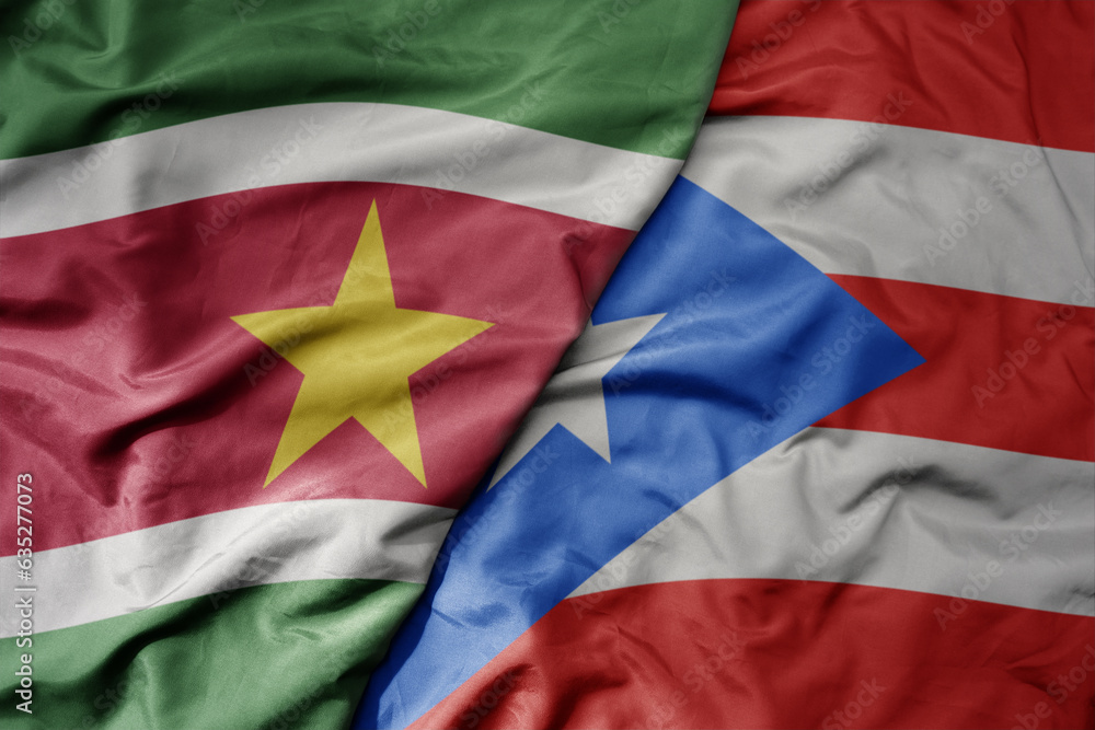 big waving realistic national colorful flag of suriname and national flag of puerto rico .