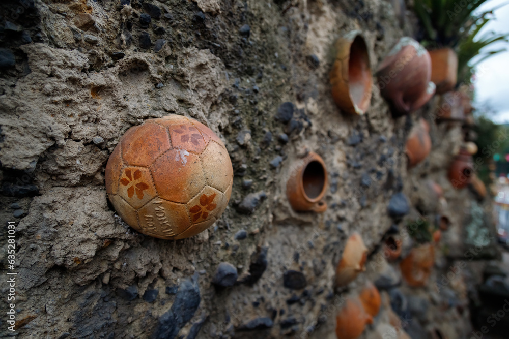 Ceramic soccer ball on a stone wall with the inscription Mongui, Boyaca